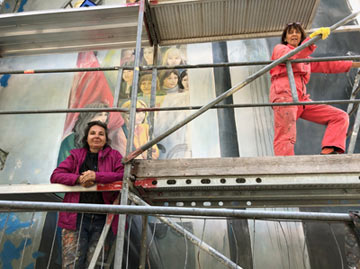 The artists Cecilia Herrero and Hildegund Schuster at work restoring the mural